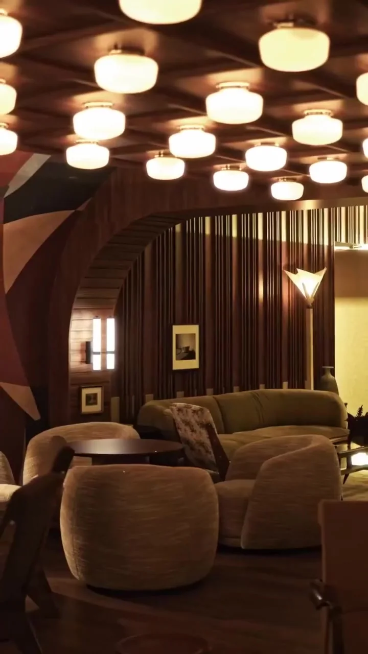 Lounge com paredes curvas em madeira e poltronas